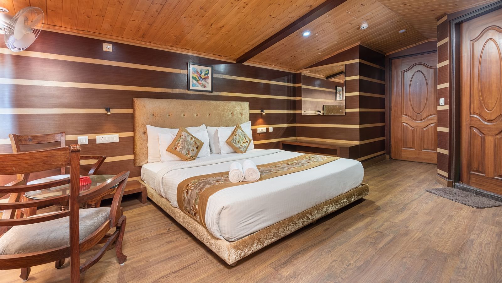 Super Deluxe Room with a king size bed and wooden finished flooring at DLS Hotels The Rock Castle.